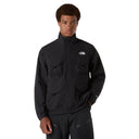 Person wearing a black jacket with a brand logo on a gray background