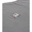 Close-up of a gray fabric surface with a small multicolor embroidered patch featuring the ATEE logo and colorful lettering.