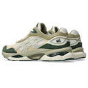 A pair of chunky low-top sneakers in beige, olive green, and off-white, featuring textured overlays, mesh panels, and a thick sculpted sole.