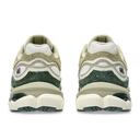 A pair of chunky retro-style sneakers shown from the back, featuring a color-blocked design in beige, white, and dark forest green on a plain white background.