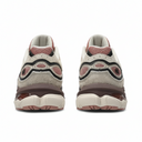 A pair of low-top sneakers shown from the back, featuring a cream suede and mesh upper with dusty pink mesh details, black and cream wavy overlays, and a chunky cream and brown sole.