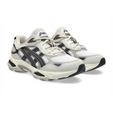 A pair of ASICS Gel-Kayano 14 sneakers in white, gray, and black, shown from a three-quarters angle on a white background.