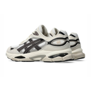 A pair of chunky athletic sneakers in off-white, beige, and black, shown from a side profile view against a plain white background.