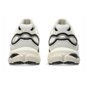 A pair of chunky platform sneakers shown from the back, featuring a cream-colored upper and sole with black accents and circular cutouts.