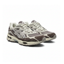 A pair of Asics athletic sneakers in taupe brown and light gray suede and mesh, shown from a three-quarters angle on a white background.