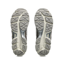 Close-up of a pair of gray athletic shoes with tread pattern on a white background