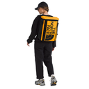 A woman wearing a black cap, black sweatshirt, black pants, and gray and yellow sneakers, shown from the back while wearing a large yellow and black The North Face insulated backpack on a plain white background.