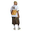 A man shown from the back wearing a white, gold, and brown geometric graphic t-shirt with the number 96 on the back, paired with brown shorts, white socks, and beige sneakers, set against a plain white background.