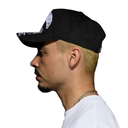 A man shown in profile wearing a black baseball cap with a white graphic logo on the front and a patterned visor, against a plain white background.