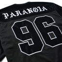 Close-up of the back of a black jersey with 'PARANOIA' in white gothic lettering and the number '96' outlined in white, on a black mesh fabric.