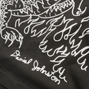 Black fabric with white embroidered design and 'Daniel Johnston' text