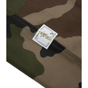 Camouflage fabric with a label featuring text and symbols.