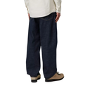 Person wearing dark blue jeans and beige shoes on a white background