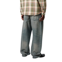 Person wearing a plaid shirt and baggy jeans on a white background