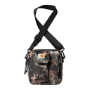 A Carhartt crossbody bag featuring a woodland camouflage pattern in brown, green, and black, with a black adjustable shoulder strap and a prominent Carhartt logo patch on the front pocket.