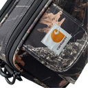 Close-up of a Carhartt camouflage pouch with a front pocket featuring the orange Carhartt logo patch, black zippers, and a woodland camo pattern.