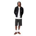 Man wearing a black jacket, white t-shirt, gray shorts, and brown shoes on a white background