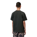 A man viewed from the back wearing a dark olive green oversized short-sleeve t-shirt and camouflage pants, set against a plain white background.