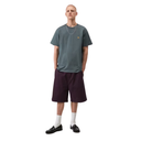 Man wearing a green t-shirt and dark shorts on a white background