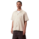 Man wearing a beige short-sleeve shirt on a white background