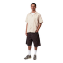 Man wearing a beige shirt and dark shorts on a white background