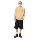 Person wearing a mustard yellow sweatshirt and black shorts on a white background