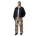Person wearing a black jacket and camouflage pants on a white background