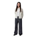 Person wearing a white jacket and dark jeans on a white background