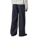 Person wearing dark blue wide-leg jeans on a white background