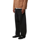 Person wearing black pants and a brown jacket on a white background
