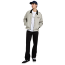 Person wearing a beige jacket, black pants, and a cap on a white background