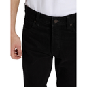 Black jeans worn by a person on a white background
