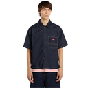 Person wearing a dark denim shirt with a red label on a white background