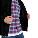 A person wearing a black zip-front jacket over a red, blue, and white plaid button-up shirt, with hands holding open the jacket, on a white background.