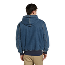 A man viewed from the back wearing a blue hooded jacket with a raw, frayed hem and cuffs, layered over a dark navy shirt and paired with khaki pants, against a plain white background.