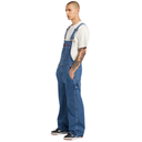 Man wearing blue denim overalls on a white background