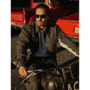 Man sitting on a motorcycle with red trucks in the background