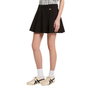 Person wearing a black skirt with white sneakers on a white background