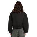 A person shown from the back wearing a black cropped jacket and gray jeans against a plain white background.