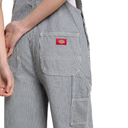Close-up of a person wearing Dickies work pants with vertical gray and white stripes, showing the back pocket and a red Dickies brand patch.