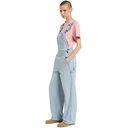 Person wearing light blue denim overalls and a pink shirt on a white background