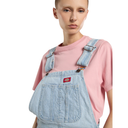 Person wearing light blue denim overalls with a pink shirt on a white background