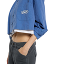 A cropped blue pinstriped button-up shirt with a white embroidered 'Dishkind' logo on the chest pocket, worn by a model with dark gray jeans against a white background.