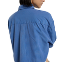 A person shown from the back wearing a blue button-up shirt with thin white vertical pinstripes, photographed against a plain white background.