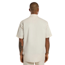 Man wearing a beige outfit from behind on a white background