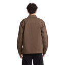 A person viewed from the back wearing a brown long-sleeve utility-style shirt and black cargo pants against a plain white background.