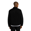 A man viewed from the back wearing a black jacket over a white undershirt and black pants, set against a plain white background.