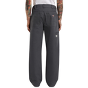 Dark gray pants worn by a person with tattoos on a white background