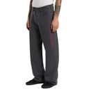 Person wearing dark gray pants with a red logo on a white background