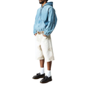 Person wearing a light blue hoodie and white shorts on a white background